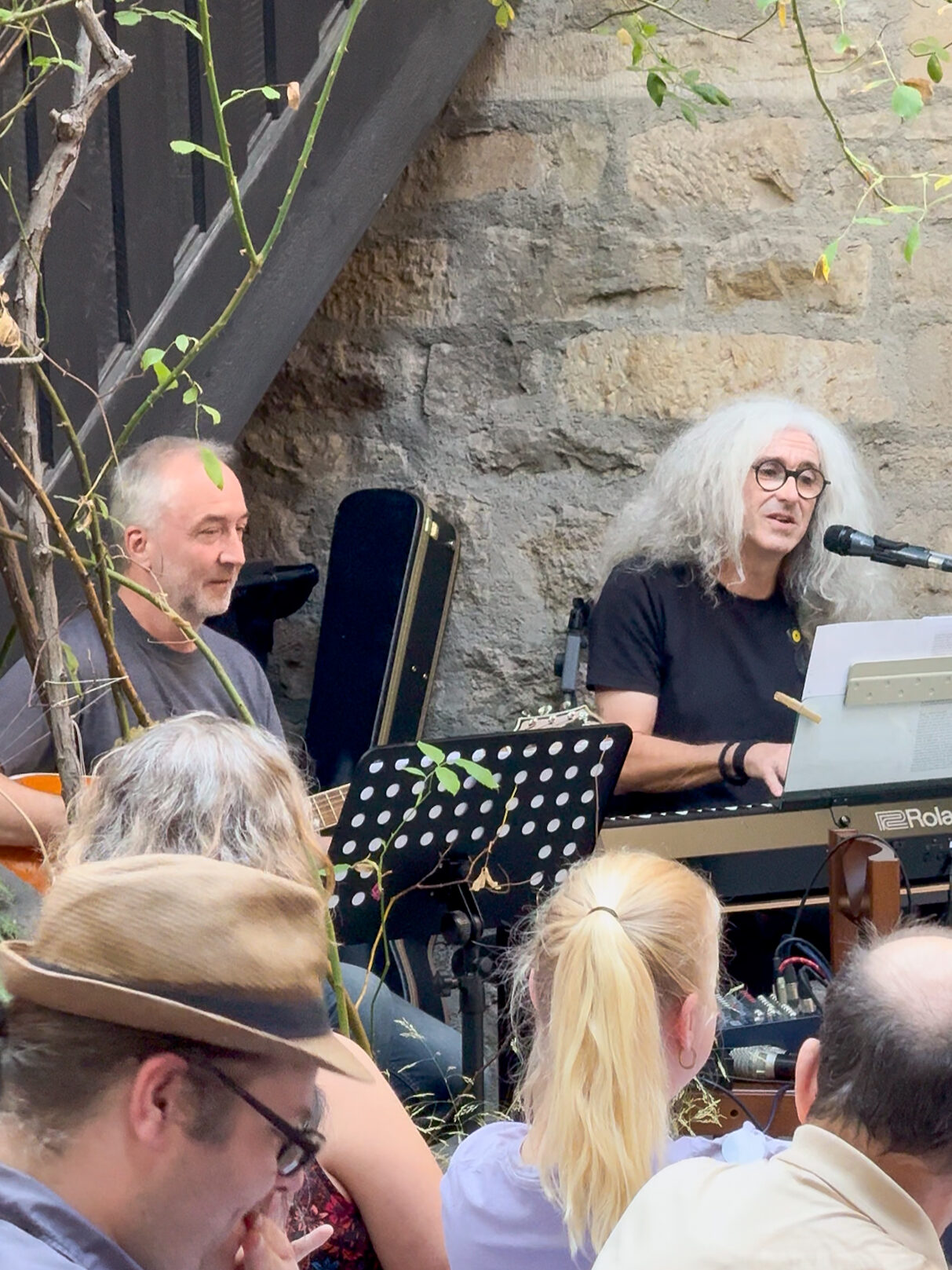 Zwei Mitarbeiter des Christophoruswerks Erfurt begleiten den Segnungsgottesdienst mit Gitarre und Klavier im historischen Innenhof der Michaeliskirche Erfurt.
